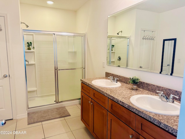 bathroom featuring vanity, a shower with door, and tile patterned floors