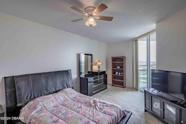 carpeted bedroom with ceiling fan, floor to ceiling windows, a textured ceiling, and access to exterior