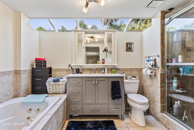 1127 Indigo Rd, Ormond Beach, FL 32174 - bathroom with a wainscoted wall, toilet, tile walls, a jetted tub, and vanity