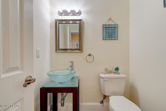 4766 S Atlantic Ave, Ponce Inlet, FL 32127 - bathroom featuring toilet, baseboards, and vanity