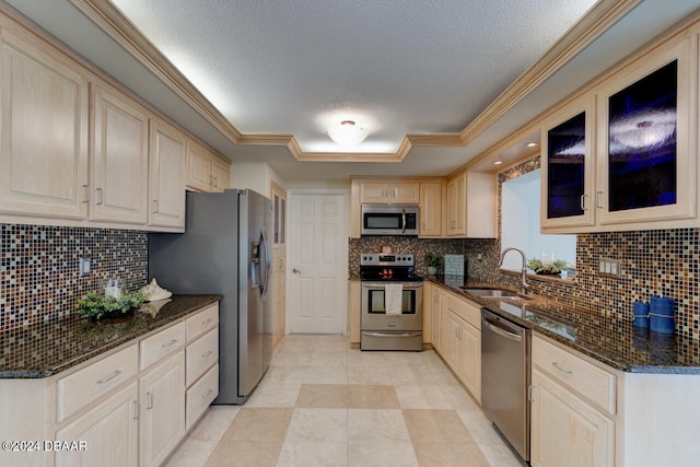 kitchen featuring dark stone counters, sink, decorative backsplash, a textured ceiling, and appliances with stainless steel finishes