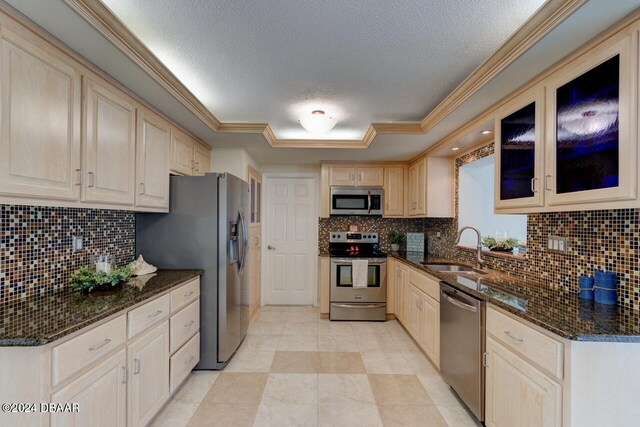 4766 S Atlantic Ave, Ponce Inlet, FL 32127 - kitchen featuring appliances with stainless steel finishes, a sink, light brown cabinets, backsplash, and dark stone countertops