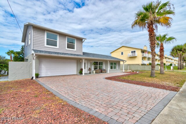 4766 S Atlantic Ave, Ponce Inlet, FL 32127 - view of front facade featuring decorative driveway, a garage, fence, and a porch