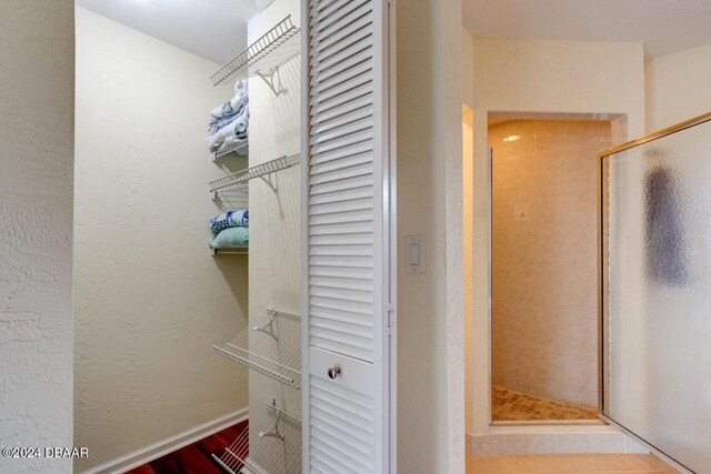 4766 S Atlantic Ave, Ponce Inlet, FL 32127 - full bath with a closet, a shower stall, wood finished floors, and baseboards