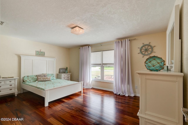 bedroom with dark hardwood / wood-style flooring and a textured ceiling