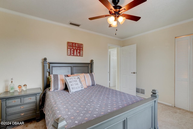 carpeted bedroom with a closet, ceiling fan, and crown molding