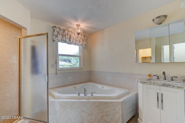 bathroom with vanity, a textured ceiling, and independent shower and bath