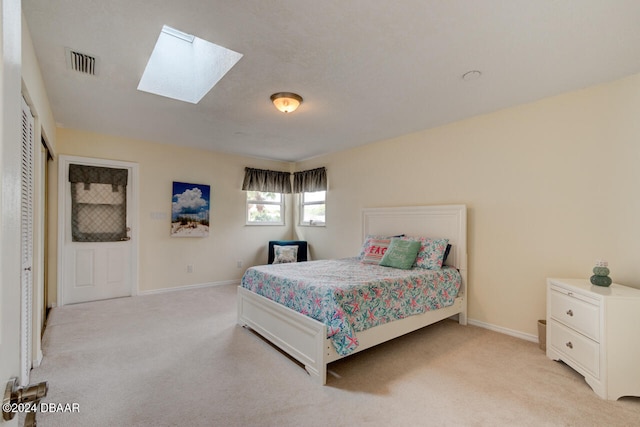 bedroom featuring a skylight and light colored carpet