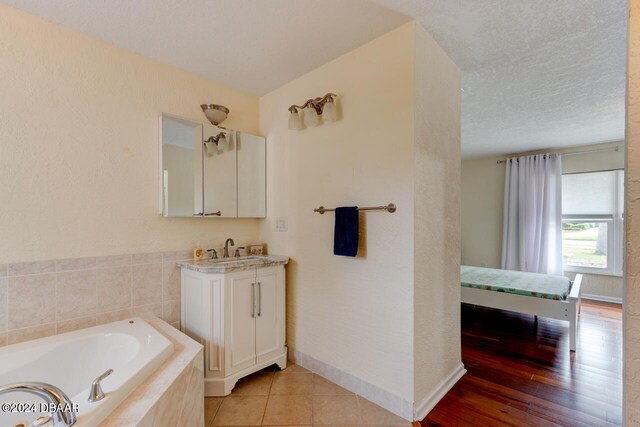 4766 S Atlantic Ave, Ponce Inlet, FL 32127 - bathroom with tiled bath, vanity, and baseboards