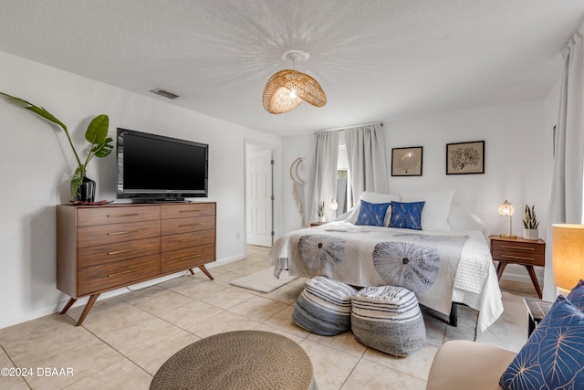 bedroom with a textured ceiling and light tile patterned flooring