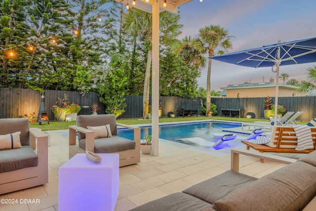 pool at dusk featuring a patio area