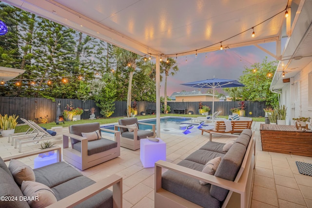 patio terrace at dusk featuring a fenced in pool and an outdoor hangout area