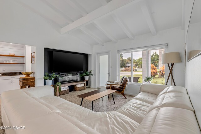 carpeted living room featuring high vaulted ceiling and beamed ceiling