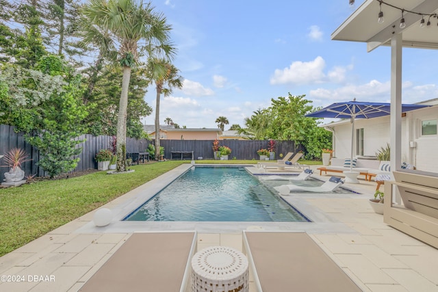 view of swimming pool with a patio and a yard