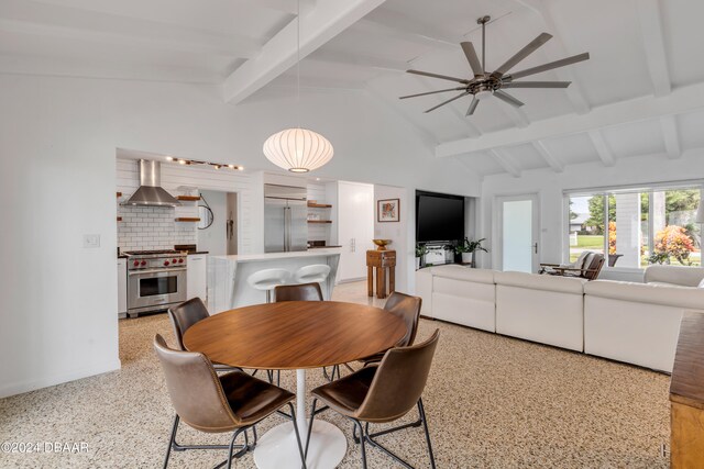 dining space featuring ceiling fan and vaulted ceiling with beams