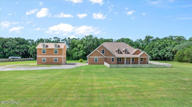 view of front of home featuring covered porch, a garage, and a front lawn