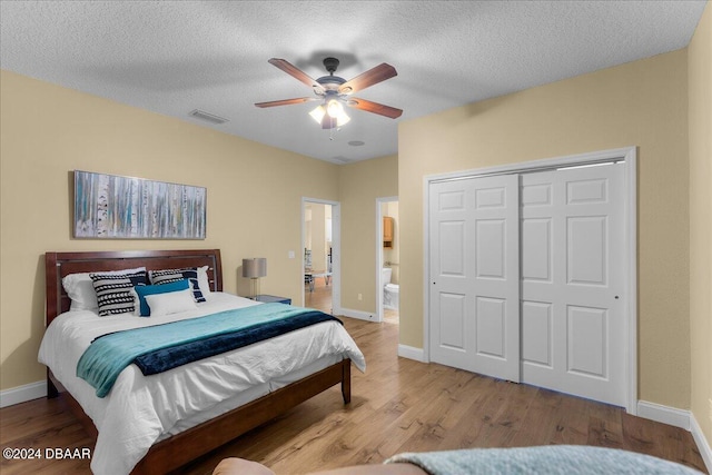 bedroom featuring a textured ceiling, light hardwood / wood-style floors, ceiling fan, and a closet