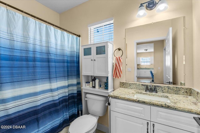 bathroom featuring curtained shower, vanity, and toilet