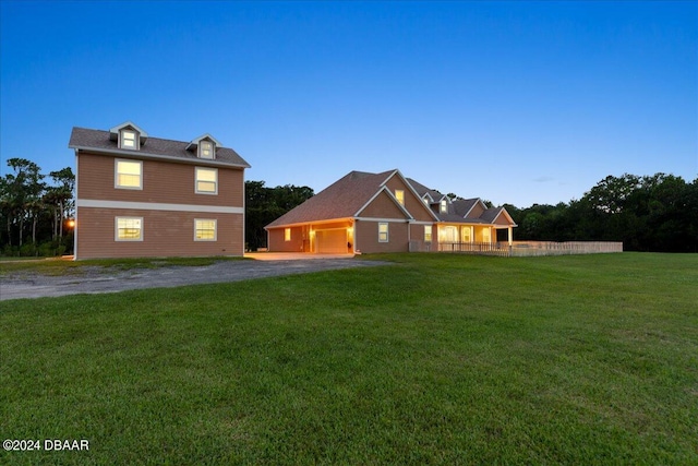 back house at dusk with a lawn