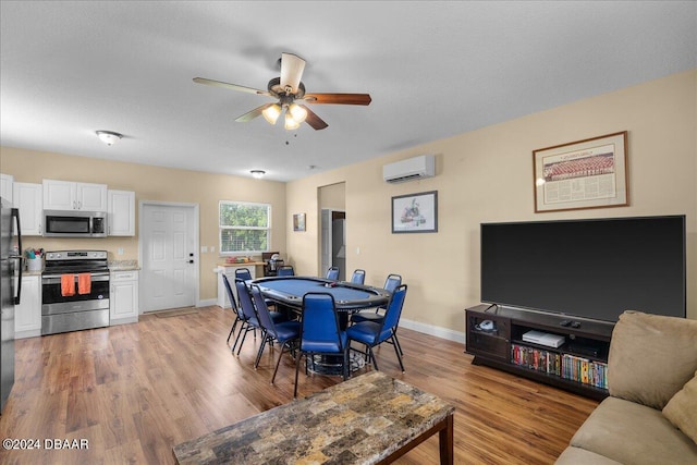 dining area featuring an AC wall unit, ceiling fan, and light hardwood / wood-style floors