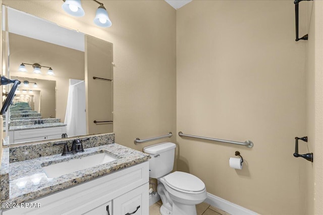 bathroom featuring tile patterned flooring, vanity, and toilet