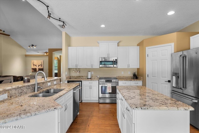 kitchen with wood-type flooring, white cabinetry, appliances with stainless steel finishes, a textured ceiling, and sink