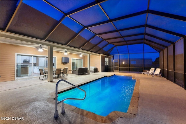 view of pool with a patio, ceiling fan, and glass enclosure