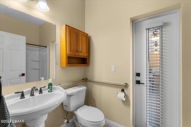 bathroom featuring a shower, sink, and toilet