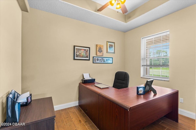 home office with ceiling fan and light hardwood / wood-style flooring