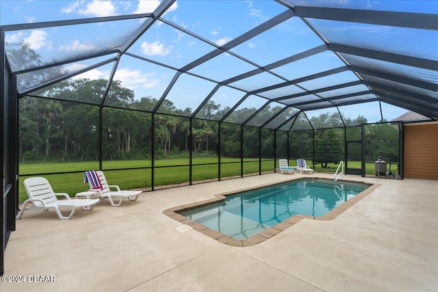 view of pool with glass enclosure, a patio area, and a lawn