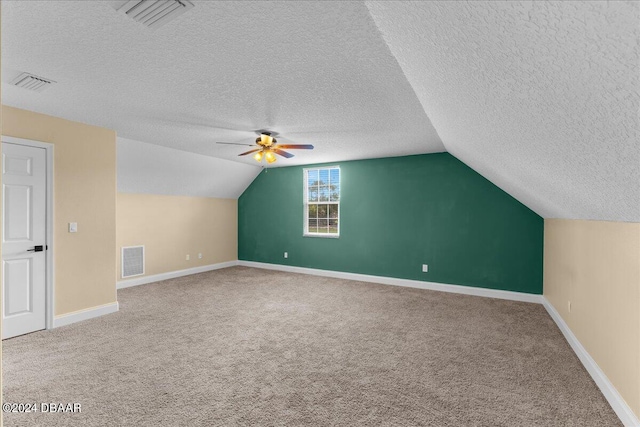 additional living space with ceiling fan, a textured ceiling, carpet flooring, and vaulted ceiling