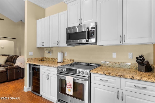 kitchen with stainless steel appliances, white cabinets, a textured ceiling, light hardwood / wood-style flooring, and wine cooler