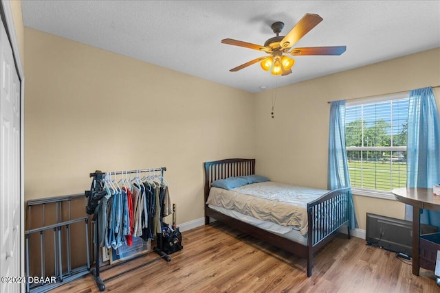 bedroom with ceiling fan, a textured ceiling, and wood-type flooring