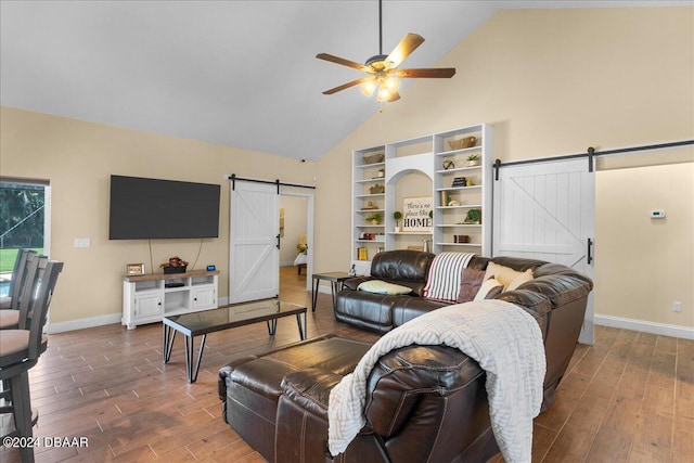 living room with high vaulted ceiling, a barn door, hardwood / wood-style flooring, and ceiling fan