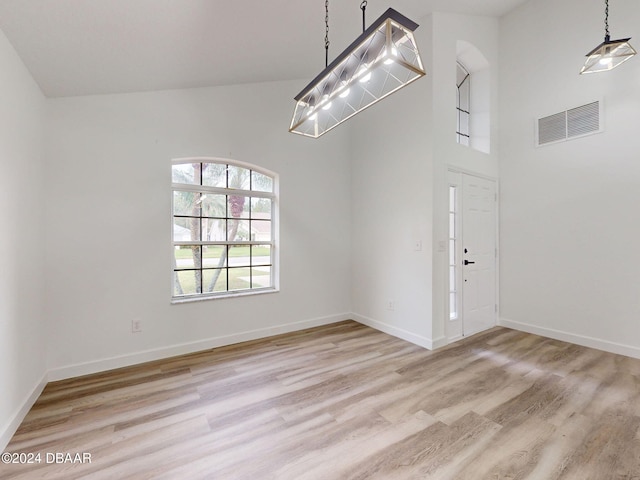 5336 Georgia Peach Ave, Port Orange, FL 32128 - empty room with light wood-style flooring, baseboards, and a towering ceiling