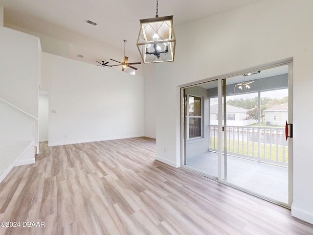 5336 Georgia Peach Ave, Port Orange, FL 32128 - spare room featuring a chandelier, light wood-style flooring, baseboards, ceiling fan, and a high ceiling