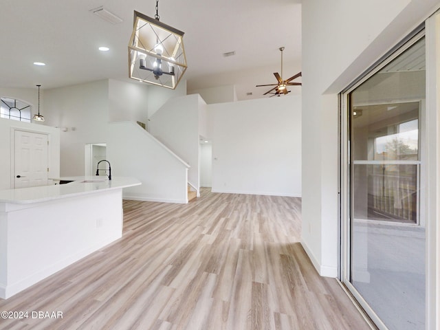 5336 Georgia Peach Ave, Port Orange, FL 32128 - unfurnished living room with light wood finished floors, a sink, a ceiling fan, stairway, and recessed lighting