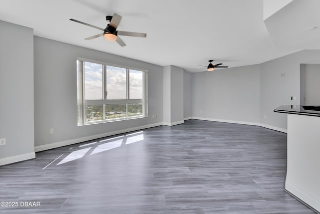 231 Riverside Dr Unit 1801, Daytona Beach, FL 32117 - unfurnished living room with a ceiling fan, baseboards, and wood finished floors