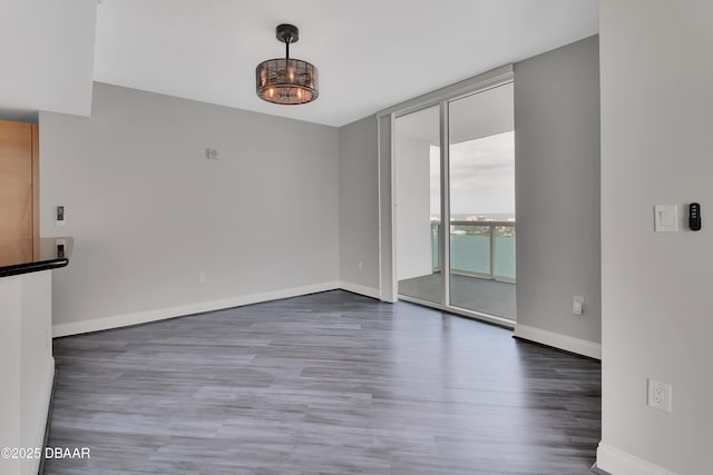 231 Riverside Dr Unit 1801, Daytona Beach, FL 32117 - unfurnished room featuring a wall of windows, wood finished floors, and baseboards