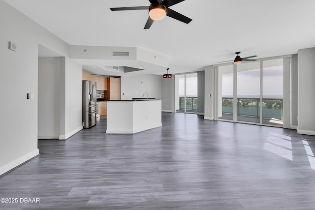 231 Riverside Dr Unit 1801, Daytona Beach, FL 32117 - unfurnished living room featuring floor to ceiling windows, dark wood finished floors, visible vents, and baseboards