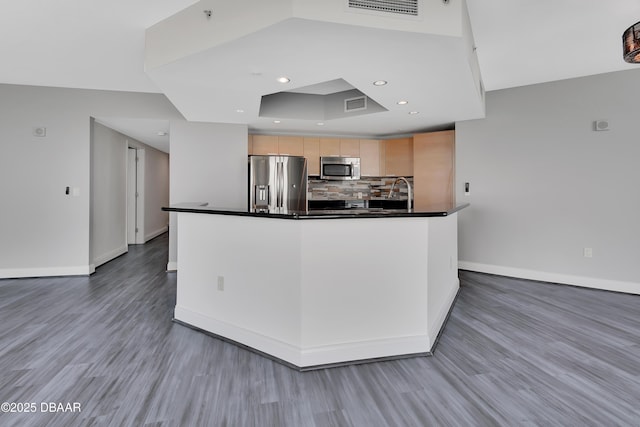 231 Riverside Dr Unit 1801, Daytona Beach, FL 32117 - kitchen with tasteful backsplash, dark countertops, visible vents, appliances with stainless steel finishes, and light brown cabinets