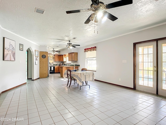 tiled dining area featuring a wealth of natural light, a textured ceiling, and ornamental molding