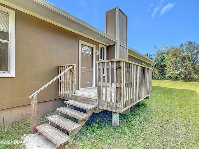 view of exterior entry with a yard