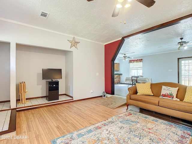 living room featuring a textured ceiling, hardwood / wood-style flooring, and ornamental molding