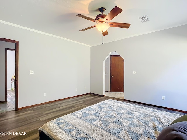 bedroom featuring hardwood / wood-style flooring, ceiling fan, and ornamental molding