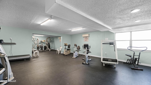 exercise room with a textured ceiling and a wall mounted AC