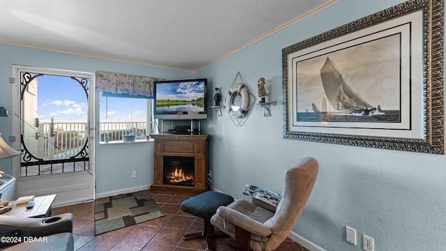 sitting room with dark tile patterned floors and crown molding