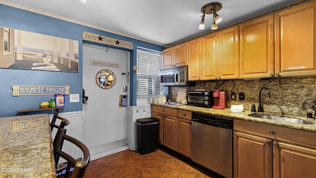 kitchen featuring dark tile patterned flooring, sink, appliances with stainless steel finishes, tasteful backsplash, and light stone counters