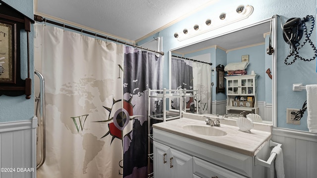 bathroom with curtained shower, vanity, a textured ceiling, and ornamental molding