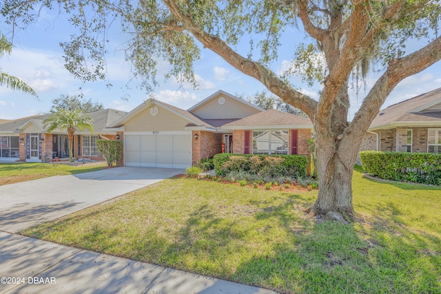 ranch-style home with a front lawn and a garage